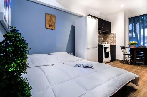 a large white bed in a room with a blue wall at Cozy Apartment in Athens 3 km from Acropolis, 5km form the beach in Athens