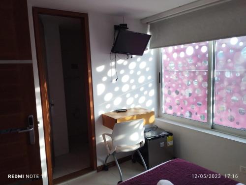 a room with a table and a chair and a window at HOTEL SAN ANTONIO PLAZA in Cali