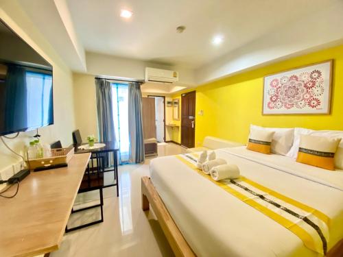 a hotel room with a large bed and a television at Chinda Boutique Hotel in Chiang Mai
