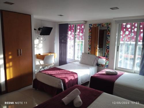 a hotel room with two beds and a window at HOTEL SAN ANTONIO PLAZA in Cali