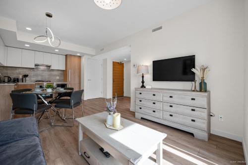 a living room with a couch and a tv on a dresser at Richmond City Center Brand New 1 Bedroom 4 Guests Apartment in Richmond