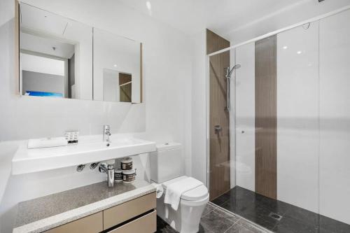 a white bathroom with a sink and a shower at Sky High Views in the Heart of Canberra in Canberra