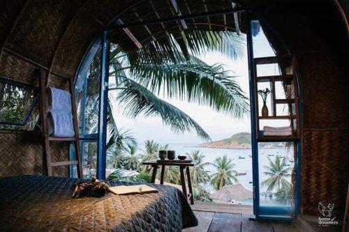 1 dormitorio con 1 cama y vistas al océano en Banana homestay en Quy Nhon
