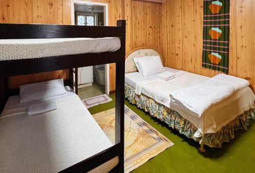 two bunk beds in a room with green floors at RedDoorz @ Monterrazas Village Homestay Baguio in Baguio