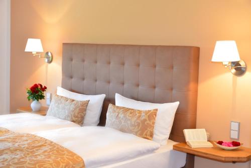 ein Schlafzimmer mit einem großen Bett mit weißer Bettwäsche und Kissen in der Unterkunft Villa Sonnenhügel in Zwiesel
