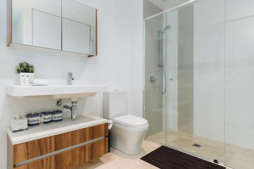 a bathroom with a toilet and a sink and a shower at 1-Bed with Amazing Views, Pool, Gym, BBQ & Parking in Canberra