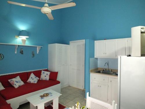 a living room with a red couch and a kitchen at Villa Preciosa in Bayahibe