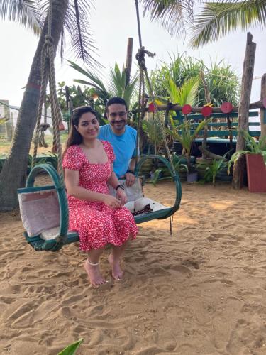 un homme et une femme assis sur une balançoire sur la plage dans l'établissement Ramya Ru Beach Home, à Galle