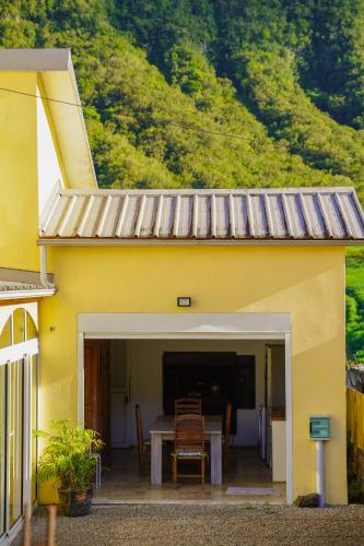 a yellow house with a table and chairs at La Villa Dos D'âne in La Possession