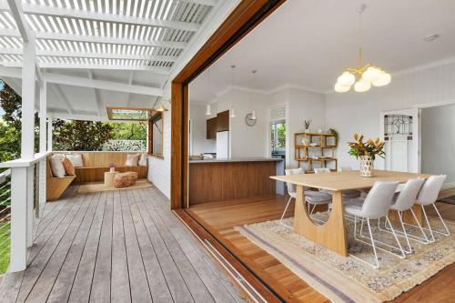 a dining room and kitchen with a table and chairs at Fuller Holidays - Daisy's Beach House - Burns St Byron Town in Byron Bay