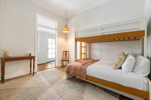 a bedroom with a bunk bed and a window at Fuller Holidays - Daisy's Beach House - Burns St Byron Town in Byron Bay
