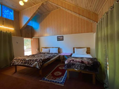 a bedroom with two beds in a room at Bloomfield Farmhouse and Eco-Resort in Darjeeling