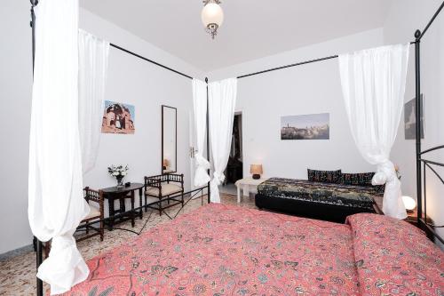 ローマにあるCasa Lindaのベッドルーム(天蓋付きベッド1台、ソファ付)