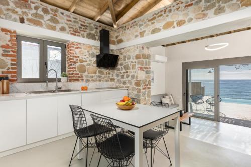 a kitchen and dining room with a table and chairs at Melivia Seafront Resort in Nea Skioni