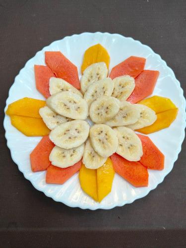 a plate with bananas and fruit on a table at Smilingface guesthouse in Sukhothai