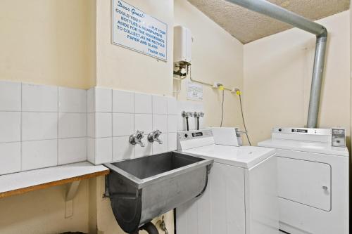 a kitchen with a sink and a washing machine at Harbour View with Opera House Overlook in Sydney