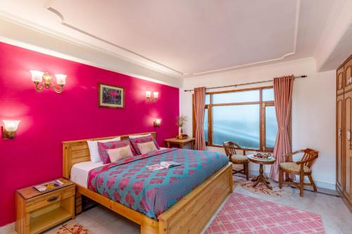 a bedroom with pink walls and a bed in a room at Alaya Stays Meridian Oak in Bharari, Shimla in Shimla