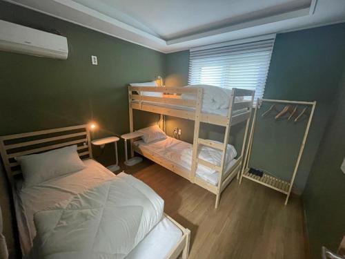 濟州的住宿－hola! Hostel，一间卧室设有两张双层床和一扇窗户。