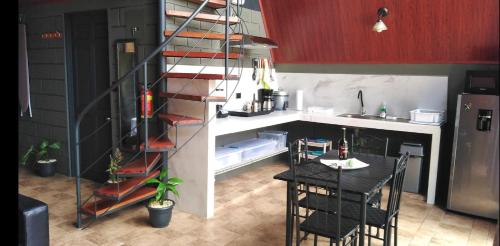 een keuken met een tafel en een ladder in een keuken bij Yarumo Lodge, Río Celeste Black Chalets in Bijagua