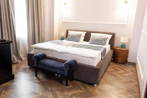 a bedroom with a large bed and a blue chair at Hotel Balkan Centar in Bijeljina