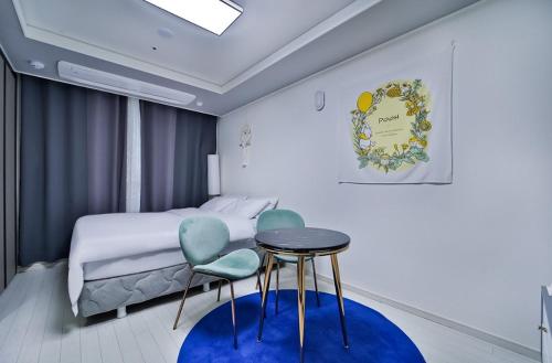 1 dormitorio con 1 cama, mesa y sillas en Moon Stay Star BnB, en Daegu