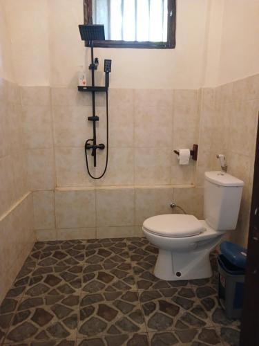a bathroom with a toilet and a shower at JOSEPH GUEST HOUSE in Kelimutu