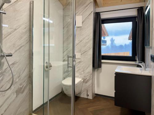 a bathroom with a shower and a toilet and a window at Chalet near Nassfeld ski resort in Carinthia in Hermagor