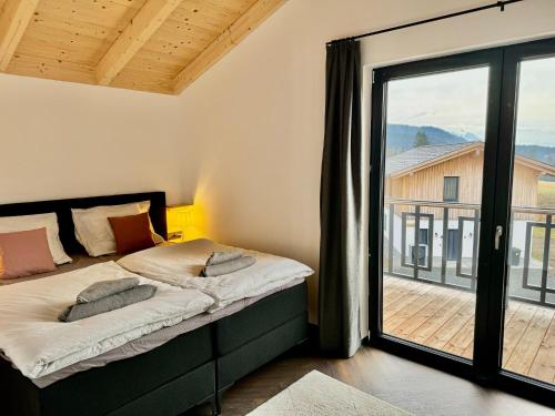 a bedroom with a bed and a large window at Chalet near Nassfeld ski resort in Carinthia in Hermagor