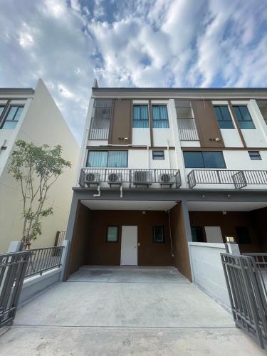an apartment building with a parking lot in front of it at New Townhouse @Central Rayong in Rayong