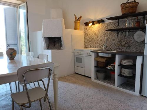 a kitchen with a table and a stove and a table and chairs at Casa Etna in Solicchiata