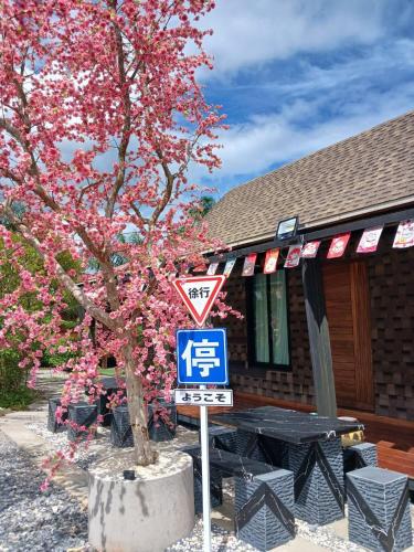 a tree with pink flowers in front of a building at กอบสุข รีสอร์ท2 k15 in Ban Ton Liang