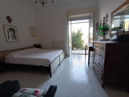 a bedroom with a bed and a dresser and a window at Casa Etna in Solicchiata