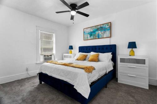 a bedroom with a blue bed and a ceiling fan at Modern Hyde Park HydeOut (FL1) in Kansas City
