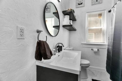 a white bathroom with a sink and a mirror at Modern Hyde Park HydeOut (FL1) in Kansas City