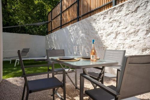 - une table et des chaises avec une bouteille de vin dans l'établissement Le Yucca - Jacuzzi Jardin Clim Wifi Parking, à Marseille