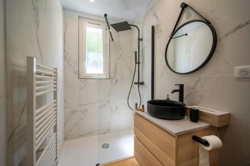 une salle de bain avec un lavabo et une douche avec un miroir dans l'établissement Le Yucca - Jacuzzi Jardin Clim Wifi Parking, à Marseille