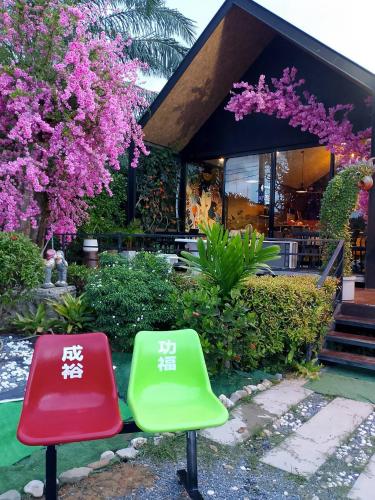 two green and red chairs in front of a building at กอบสุข รีสอร์ท2 k15 in Ban Ton Liang