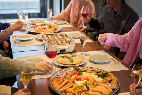 a group of people sitting around a table with food at Villa JacoO-ヴィラじゃこまる- in Sanuki