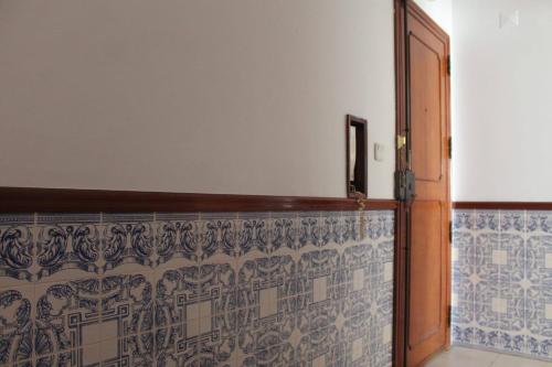 Habitación con una pared de azulejos azules y blancos. en GG Massama en Fontainhas