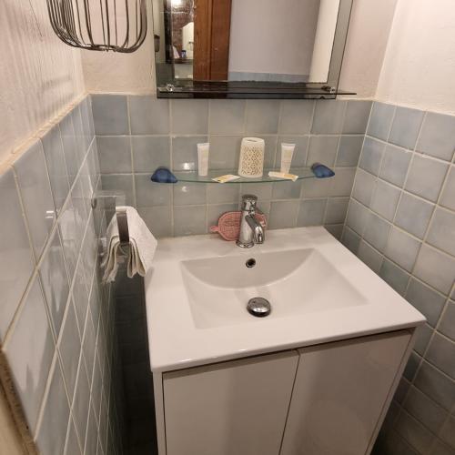 une salle de bain avec un lavabo blanc et un miroir dans l'établissement Logement équipé, à Grimaud