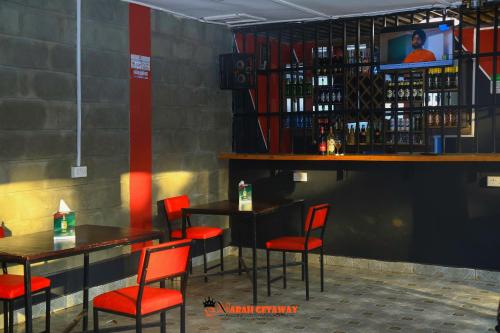 a restaurant with red chairs and tables and a television at Emarah Getaway Sagana in Sagana