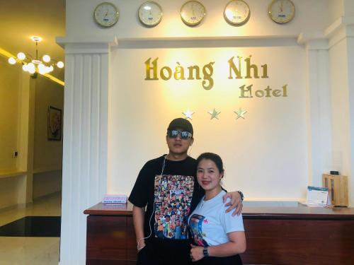 mężczyzna i kobieta stojący przed hotelem w obiekcie Khách Sạn Hoàng Nhi w mieście Pleiku