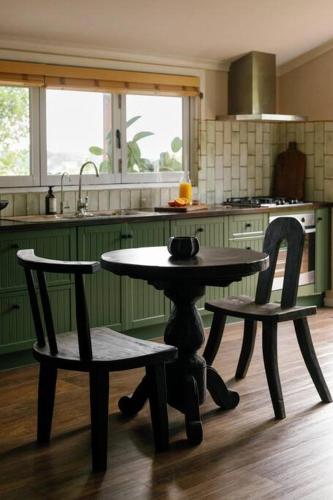 a table and two chairs in a kitchen at The Honey Barn, Wabi-Sabi Cottage Byron Hinterland in Clunes