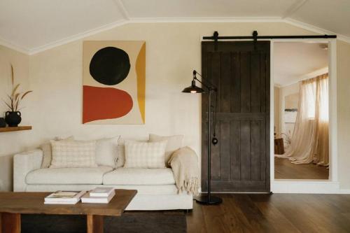un soggiorno con un divano bianco e un tavolo di The Honey Barn, Wabi-Sabi Cottage Byron Hinterland a Clunes