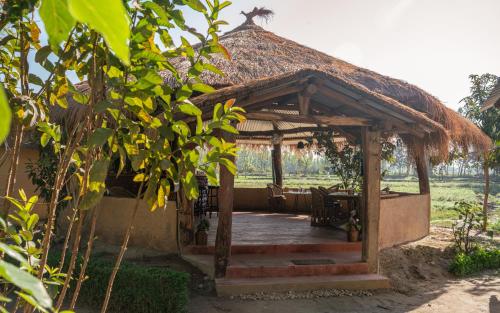 a wooden gazebo with a table and chairs at Sunsetview Bardia in Bardia