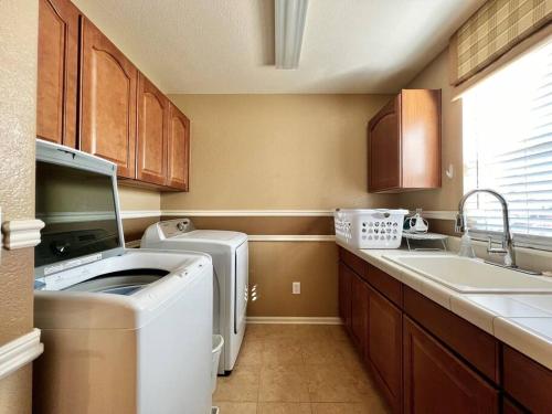 a kitchen with a washing machine and a sink at Large 5BR Retreat - Hot Tub - Gym - Games - I-25 in Castle Rock