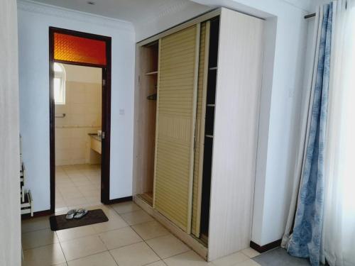 a bathroom with a walk in shower and a mirror at Lux Suites Nyali Beachfront Apartments in Mombasa