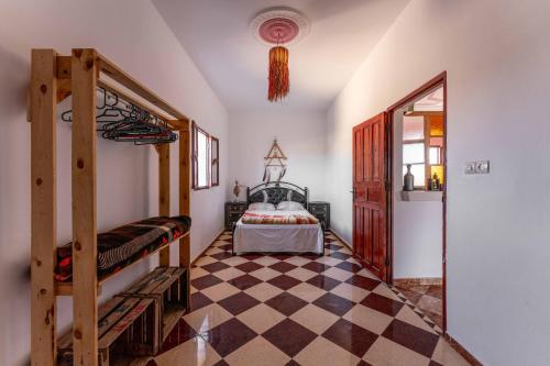 a bedroom with a bunk bed and a checkered floor at Ayour Hostel in Sidi Kaouki