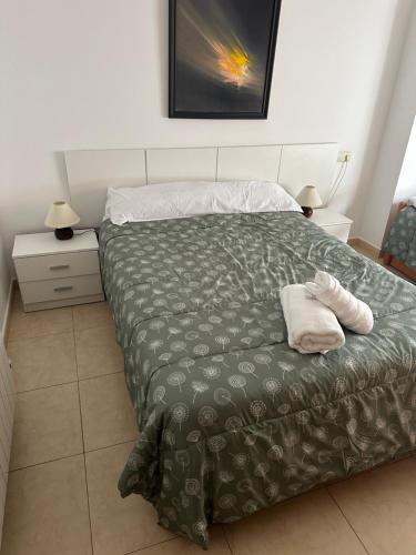 a bed with two white towels on top of it at Apartamentos L'Ainsa in Aínsa