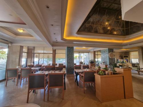 - un restaurant avec des tables et des chaises dans une salle dans l'établissement Perlo Hotel City, à Antalya